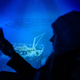 A woman takes a picture at a replica of the shipwreck